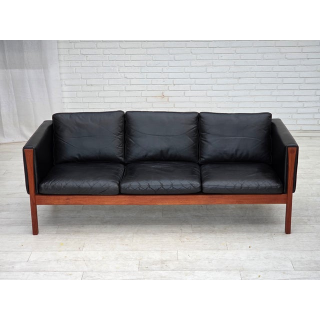 1960s, Danish design by H.J.Wegner. 3-seater sofa model CH 163. Original black leather, teak wood. Partially restored: new...