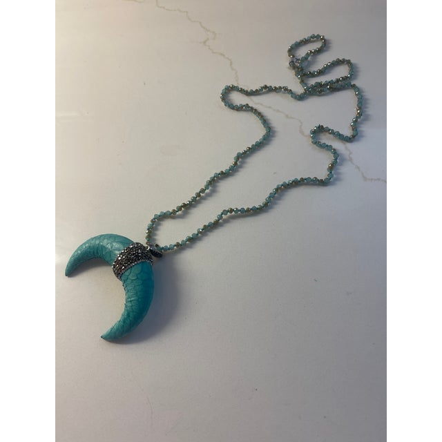 17" long aqua beaded necklace with leather pendant at end finished with silver beading
