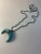 17" long aqua beaded necklace with leather pendant at end finished with silver beading