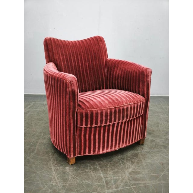 Elegant Danish Modern lounge armchair dating from the 1950s, distinguished by its sculptural curved silhouette, generous...