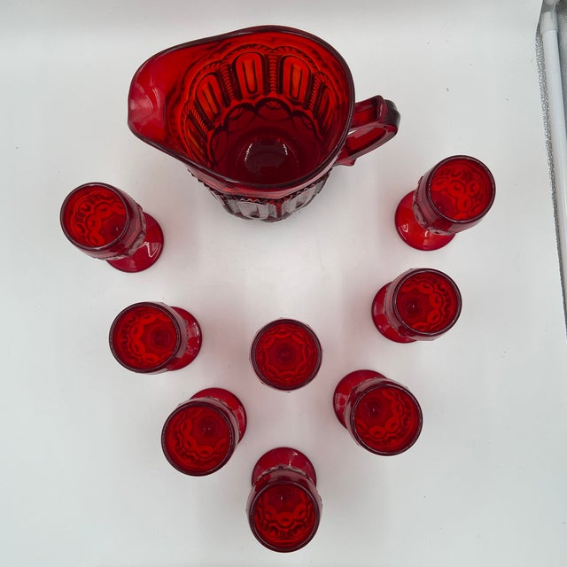 A vintage L.E. Smith Moon & Stars beverage set in rich ruby red pressed glass. This collectible American glassware...