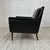 Classic mid century modern black vinyl lounge chair with walnut frame, base, and legs. This chair is well-built and heavy.