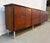 Striking Mid-Century Modern credenza featuring beautifully grained wood veneer, sleek minimalist cabinet doors, and a...