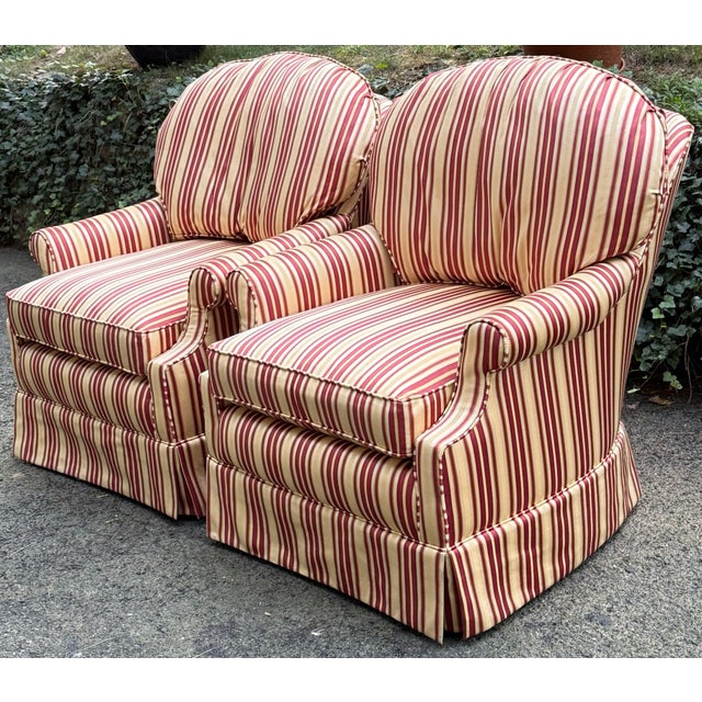 Beautiful pair of swivel lounge chairs by Calico corners. Upholstered in a classic pale yellow and red striped fabric,...