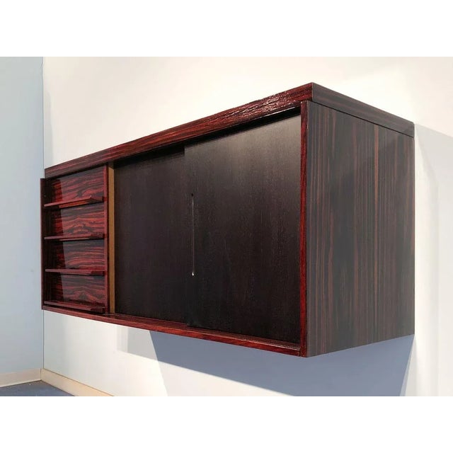 Italian mid-century modern suspended sideboard in precious Macassar ebony from the 1950s. The suspended sideboard has a...