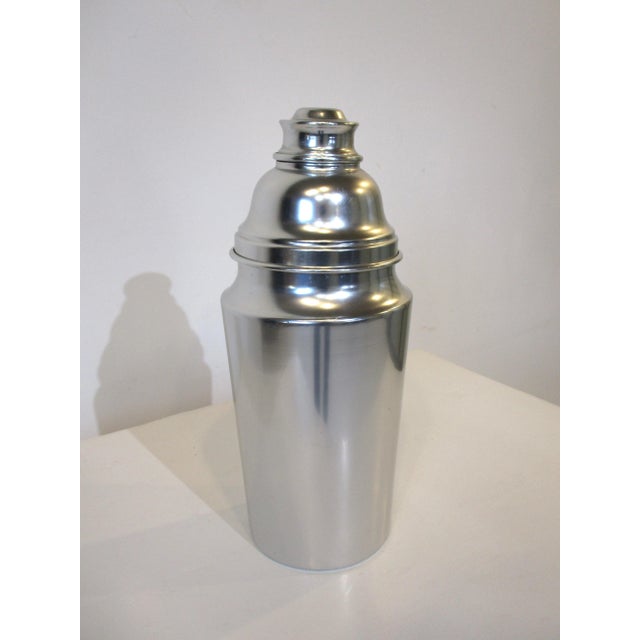 A very large aluminum party or hotel sized cocktail shaker with built in strainer to the lid and small cap . This would be...