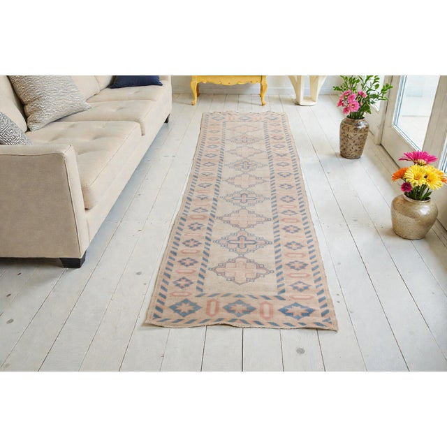 This is a vintage Turkish Oushak rug from the Mid 20th Century. The piece was hand-knotted.