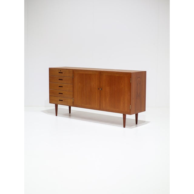 A beautiful sideboard designed by kai winding in denmark during the 1960s. Crafted from teak, the cabinet features a...
