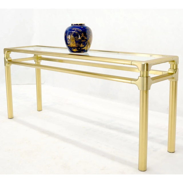 Mid-Century Modern solid brass profile base glass top console or sofa table. In style of Mastercraft.