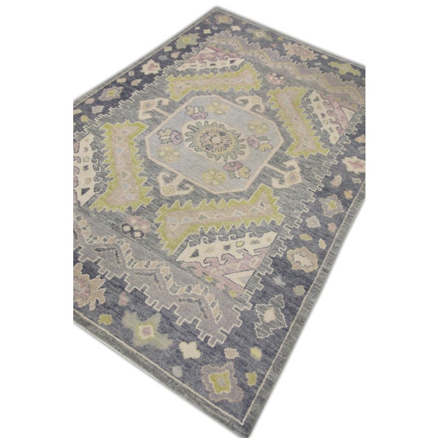 This modern Turkish Oushak rug is a stunning piece of art that has been handwoven using traditional techniques by skilled...