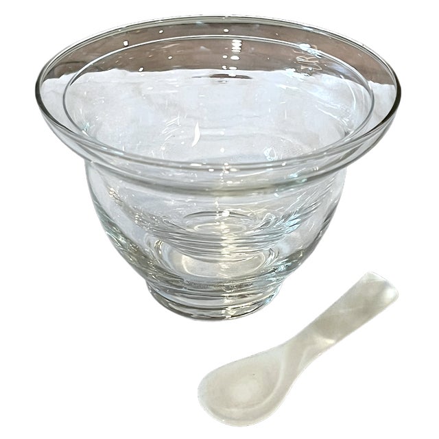 An elegant vintage glass caviar server accompanied by a petite mother-of-pearl spoon, combining beautifully simple form...