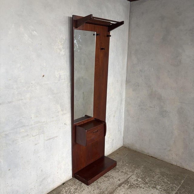 A beautifully designed mid-century teak gentleman’s hallway stand, combining practical entranceway storage with the clean...