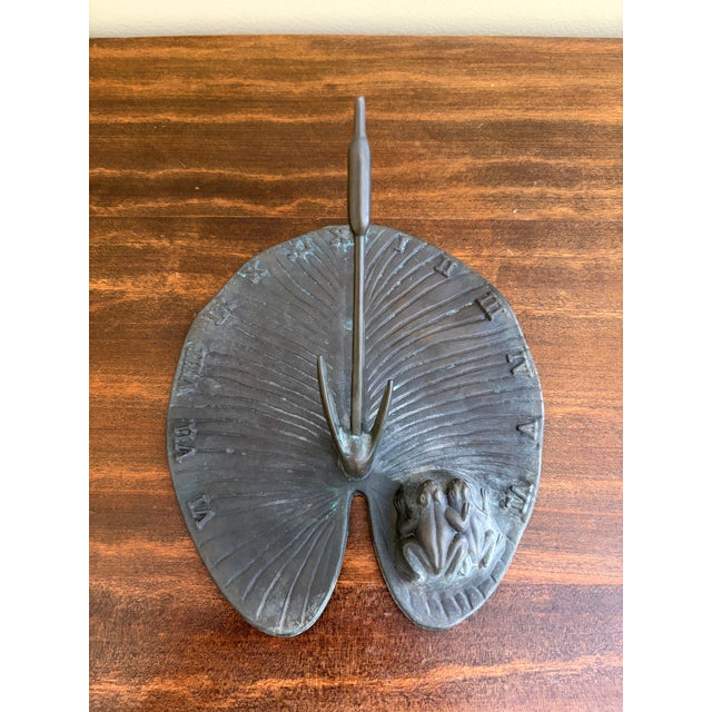 A stunning vintage iron garden sundial featuring a two charming frogs on a lily pad USA, Late 20th Century Measures: 7.5"W...