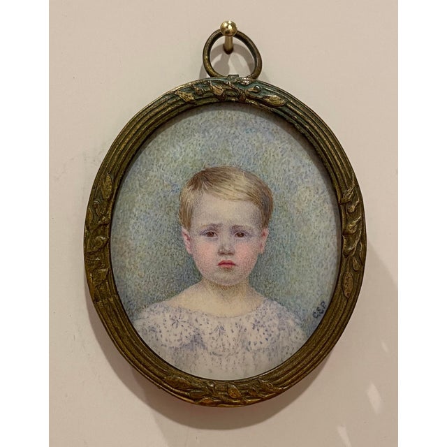 Antique portrait miniature of a small child, looking slightly unhappy. Watercolor on hard surface, signed CSP (the S might...