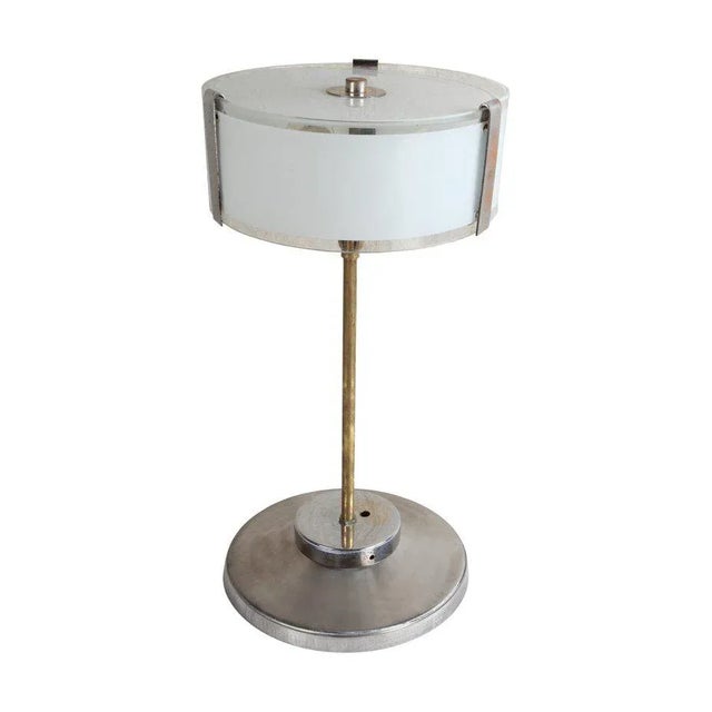 Pair of chrome Mid-Century Modern table lamps with frosted glass shade. Brass stem. Each lamp has two standard size light...