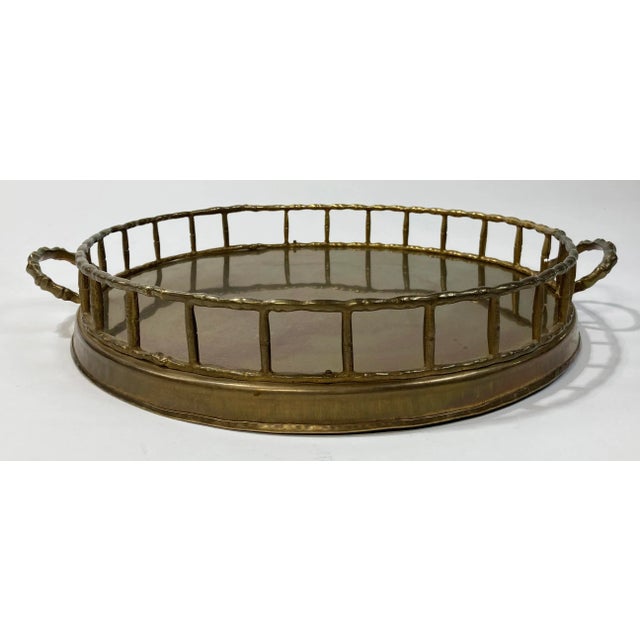 Vintage round brass tray with a faux bamboo rail framing outer rim and handles. Rich patina gives an antiqued look....