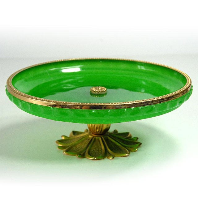 A beautiful plate made of pressed glass in an intense green color. Finished with gold-colored metal details. Signed. It...