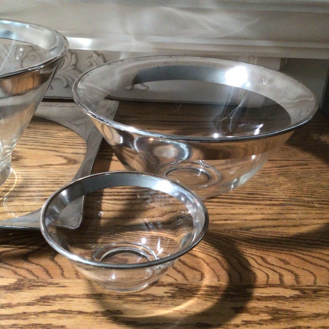 2 different chip and dip bowls with metal dip bowl holder that clips on the side of chip bowl. One large serving bowl on a...