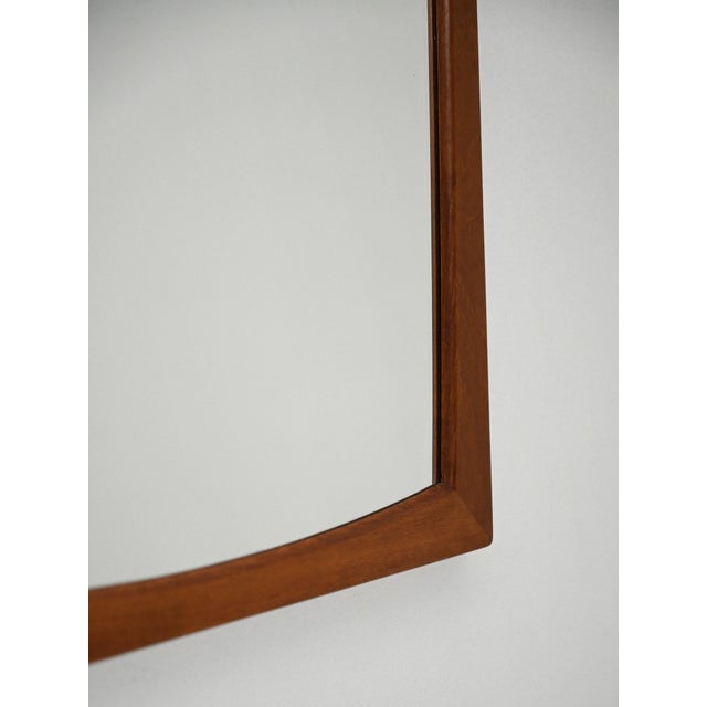 Danish mirror with a rectangular teak frame and slightly curved lines. Made by Aksel Kjersgaard with the original...