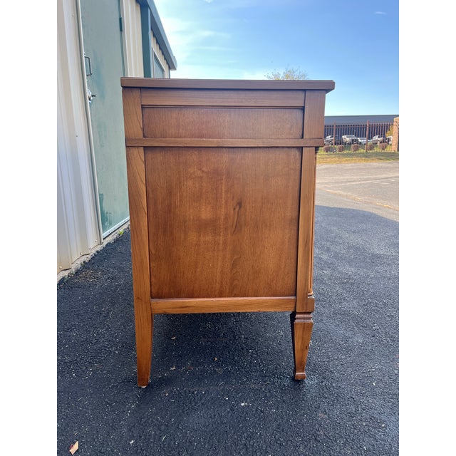 A vintage fruitwood triple dresser in a neoclassical style. Light coloring and complex burlwood grain patterns on the...