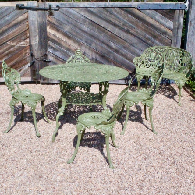 Consisting of a bench, four chairs and a round dining table, this versatile group is freshly painted in the green color of...