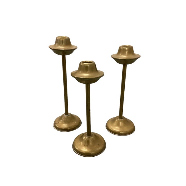 A set of three solid brass candlesticks . The model was manufactured in Denmark during the 1960s. These Minimalist...