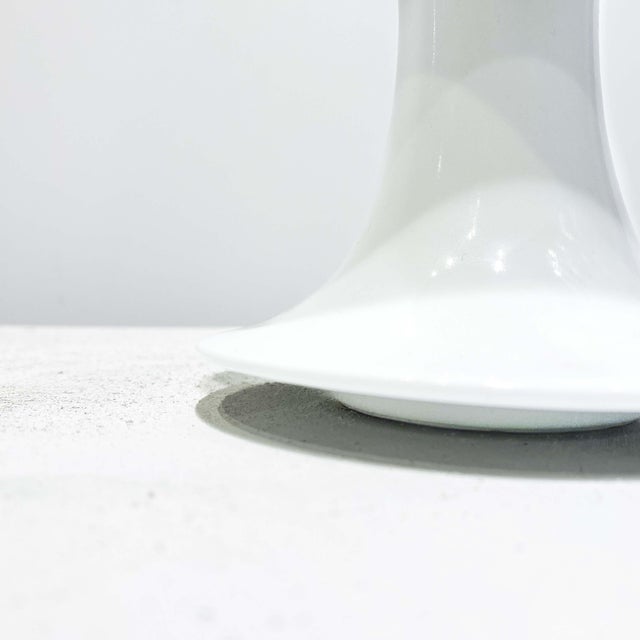 Jan van der Vaart’s "Vase" (1980) is a 16.5 x 13 x 13 cm porcelain piece with a white-glazed finish. Its flared top and...