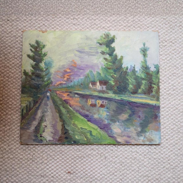 This 20th Century French Evening Walk Painting depicts a quiet waterside path at dusk, rendered with expressive brushwork...