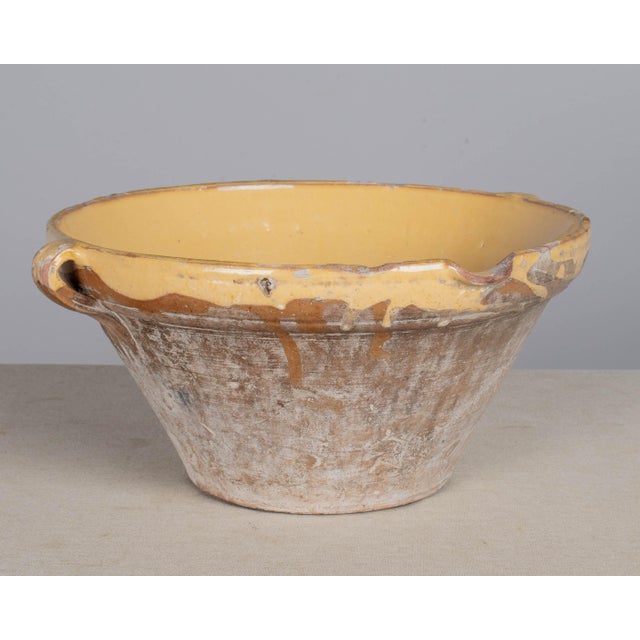 An early 20th century Country French yellow glazed earthenware pottery tian or grésale bowl. Originating from Provence and...