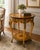 An elegant vintage Italian side table featuring exquisite marquetry inlay work and a refined two-tier form. The circular...
