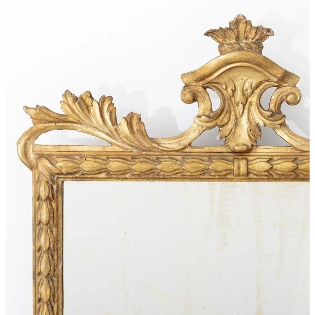 Louis XVI Style Giltwood Mirror, 19th century, with shield and scroll form crest with carved floral border. Mirror plate:...