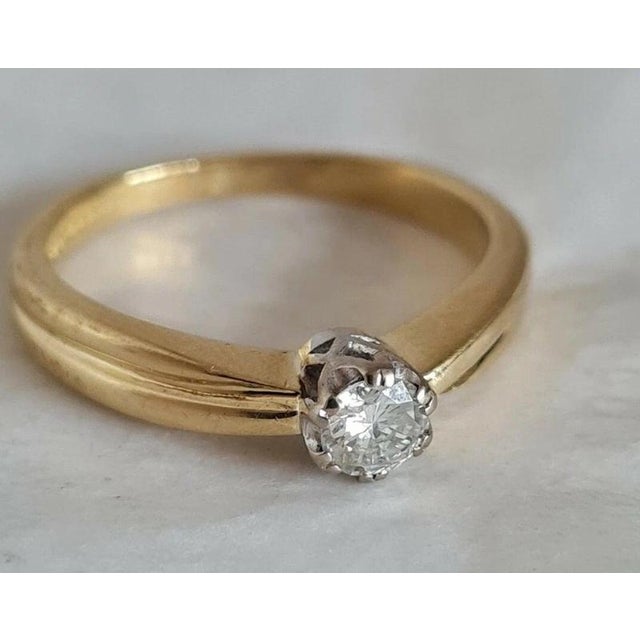 A fine vintage 18ct yellow gold solitaire ring dating to 1994, featuring a classic and timeless single-diamond design. The...
