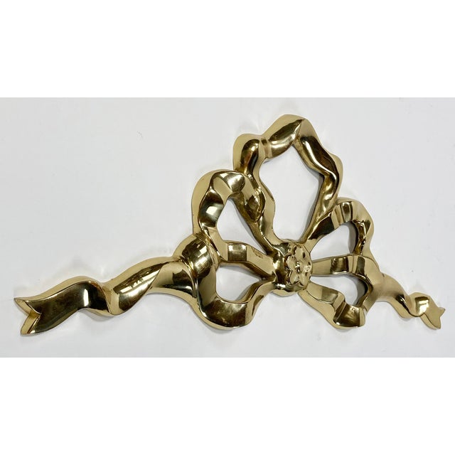 Vintage polished brass wall hanging in shape of ribbon and bow. Flower at tie point. Hanger for mounting. Wonderful as...