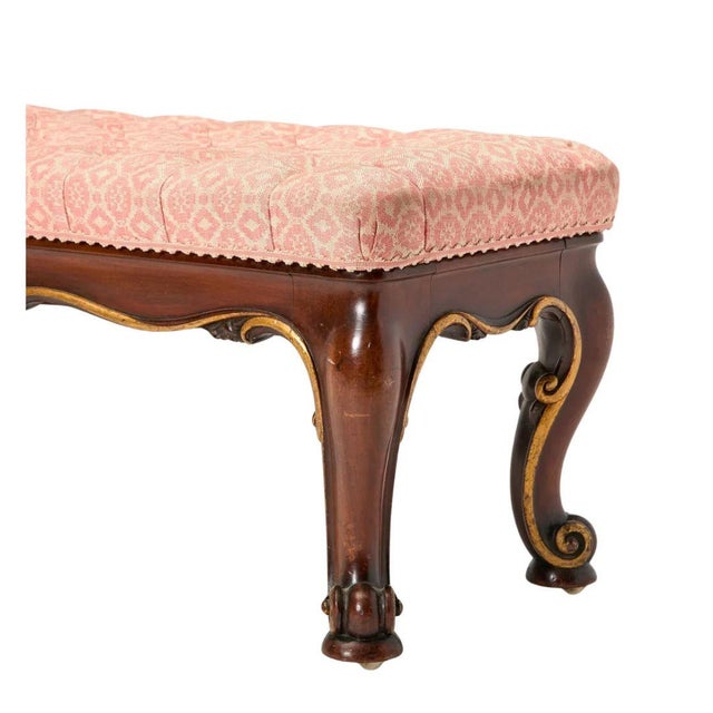 A Regency style window bench features a richly figured mahogany frame with graceful scroll form legs and delicate gilt...