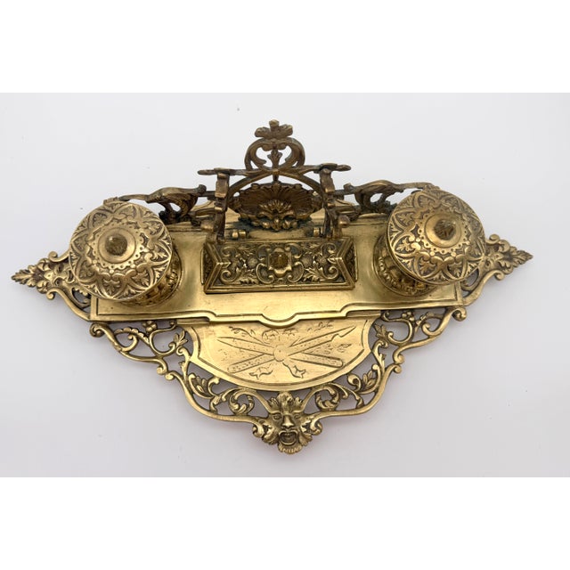 Elevate your workspace or library with this exceptionally detailed vintage Baroque Revival cast brass double inkwell desk...
