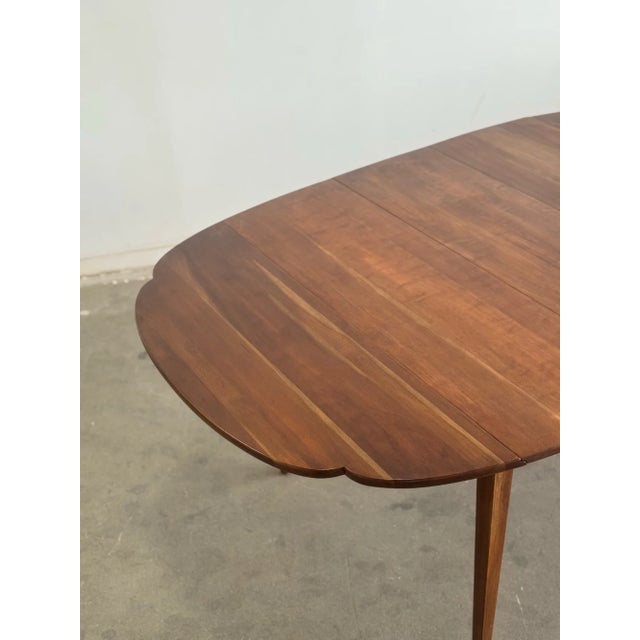 W54.5 - W66.5 D42 H30 KC24 Leaf W12 This minimalistic dining table features dainty gently tapered legs, a walnut top with...