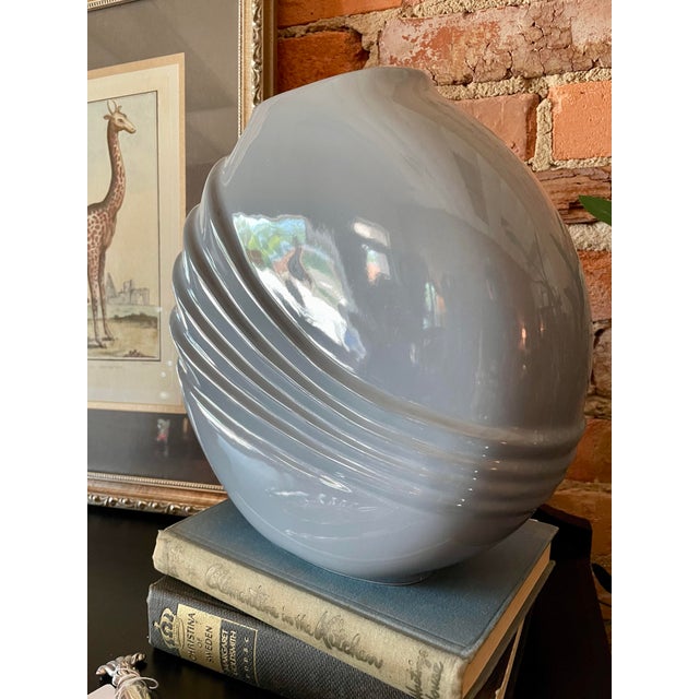 Vintage 1980s ceramic vase in the postmodern style with a glossy finish and powder blue hue. Measures 10.25"W x 10"H x 3.5"D.