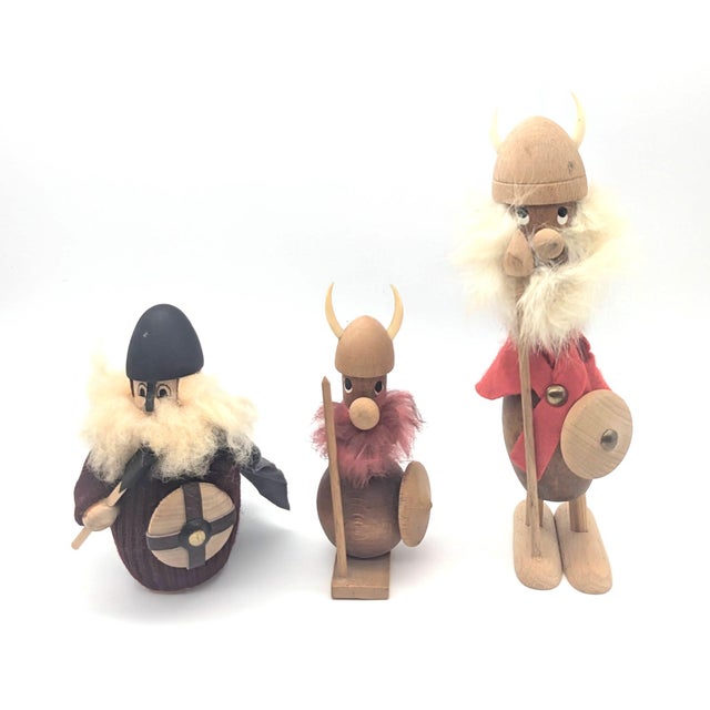 Offered are 3 whimsical vintage Danish Norsemen figurines - wood-carved Vikings with helmets, shields, and weapons. The...