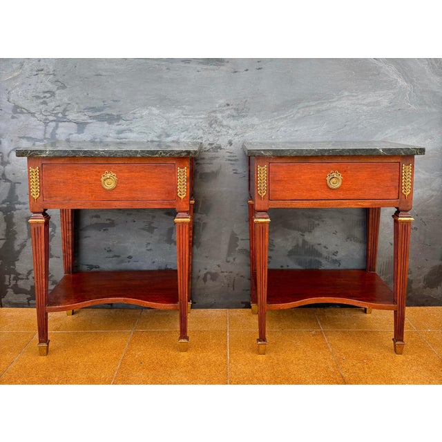 Elegant pair of French bedside tables in the Louis XVI style, dating from the 20th century. Each table is crafted in solid...