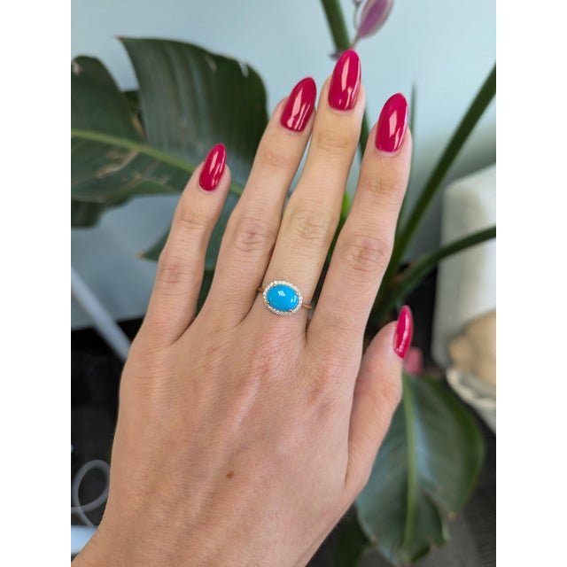 A Sleeping Beauty turquoise in a clean, robin's-egg blue is set east-west at the centre of this solid 14K yellow gold...