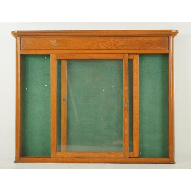 Vintage French City Hall wall mounted bulletin board display case. It features an oak medium stained wood frame, two glass...