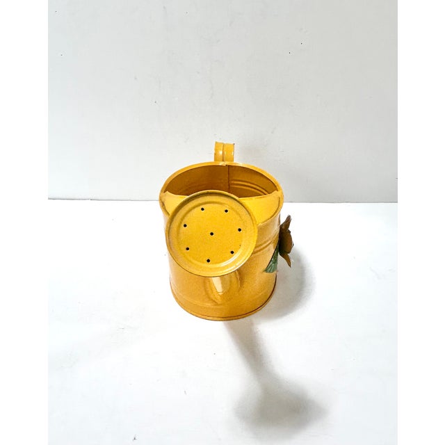 Charming vintage yellow toleware watering can featuring a dimensional white floral appliqué, perfect as a cottage garden...