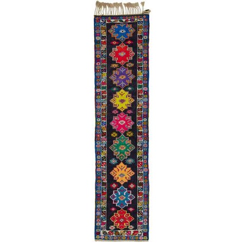 This exquisite runner rug is a rare example of tribal craftsmanship, hand-knotted by the women of the Herki tribe during...