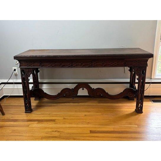 featuring rich dark wood construction and intricate hand-carved detailing throughout. The rectangular top is supported by...