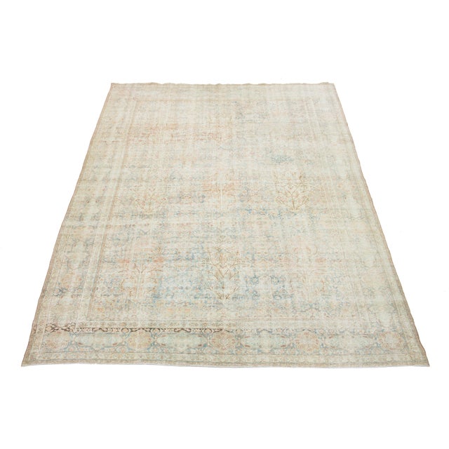 Discover the exquisite charm of this antique Tabriz hand-knotted distressed wool rug. Its captivating blue field features...