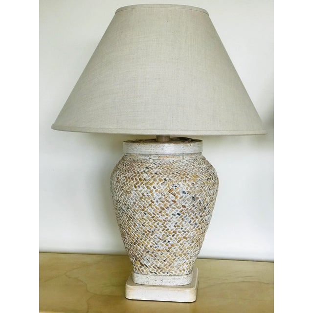 A pair of lidded baskets mounted as lamps. Finished in a cerused wash with matching bases and hardware. A stylish...