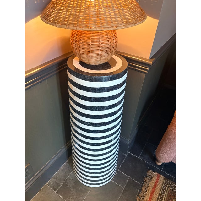 A bold sculptural pedestal by Wildwood featuring alternating bands of natural black and white stone inspired by the...