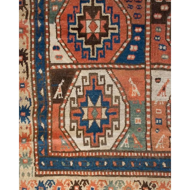 A late 19th century Caucasian Moghan rug with eight bold multicolored geometric medallions, surrounded by multiple...
