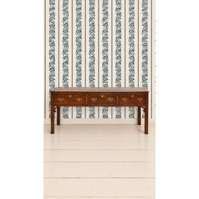 A handsome late 18th-century English dresser base or serving table crafted from richly grained oak with a beautifully...
