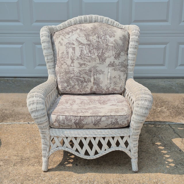 This is a charming white wicker wingback lounge chair with generous proportions and lattice detailing. The cushions are...
